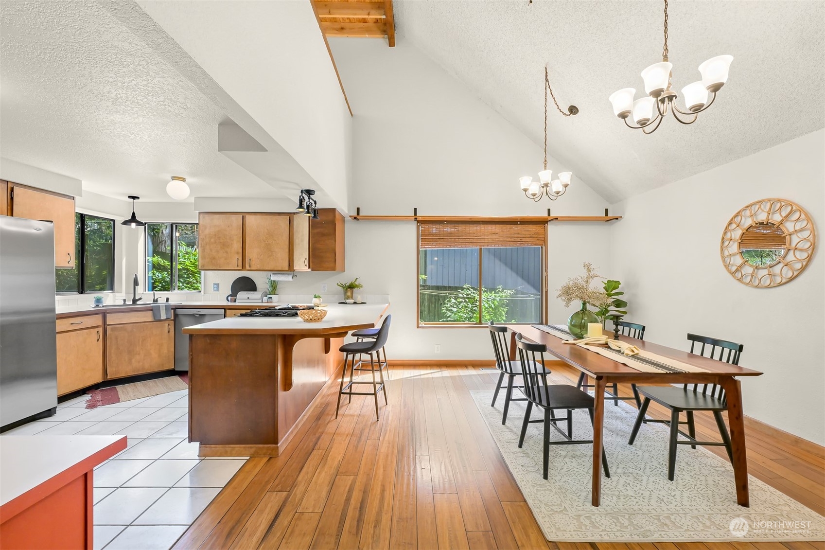 1506 Willowbrook Place Bellingham, WA 98229 - Photo 22 of 37 a kitchen with stainless steel appliances kitchen island granite countertop a table chairs in it and a wooden floors