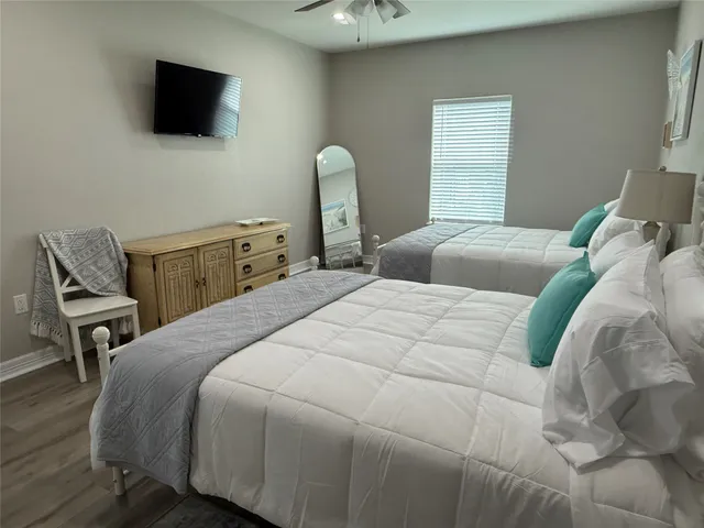 a bedroom with a bed chair and television