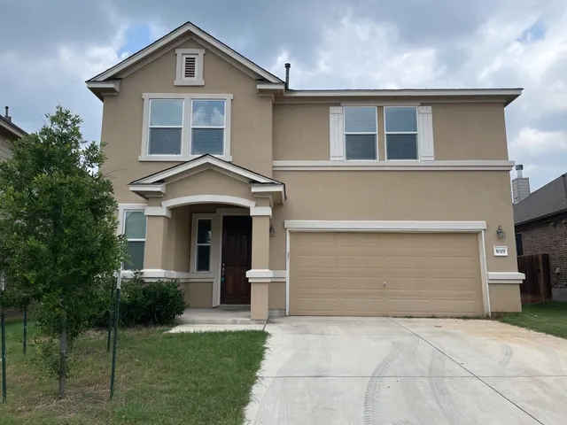a front view of a house with a yard and garage