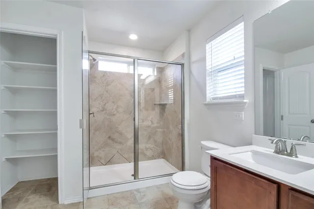 a bathroom with a toilet sink vanity and mirror