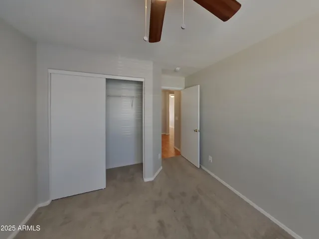 an empty room with a window and a ceiling fan