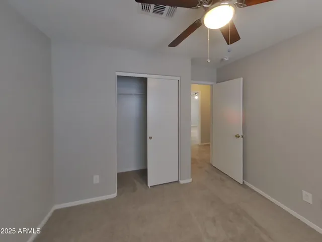 an empty room with a window and a fan