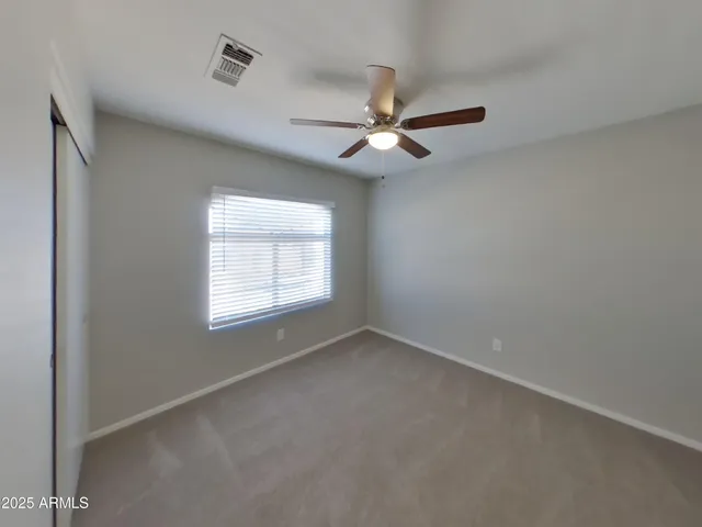an empty room with chandelier fan