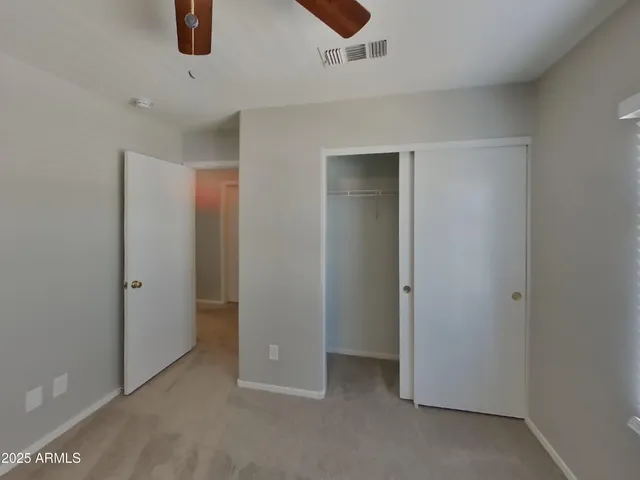 an empty room with a window and a fan