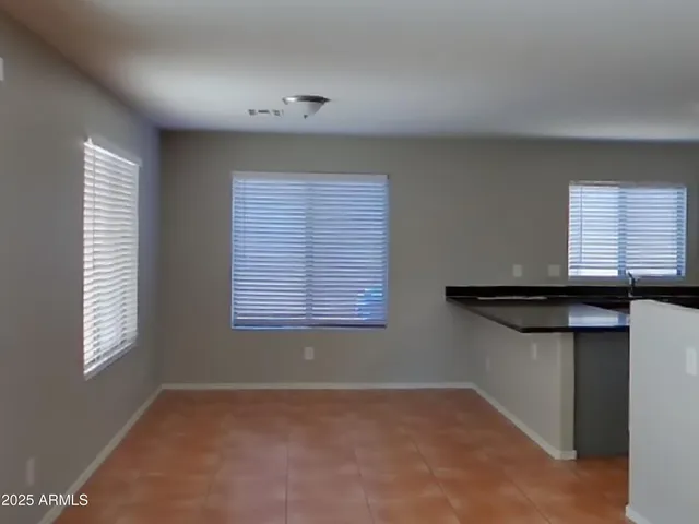 a view of an empty room with a chandelier fan