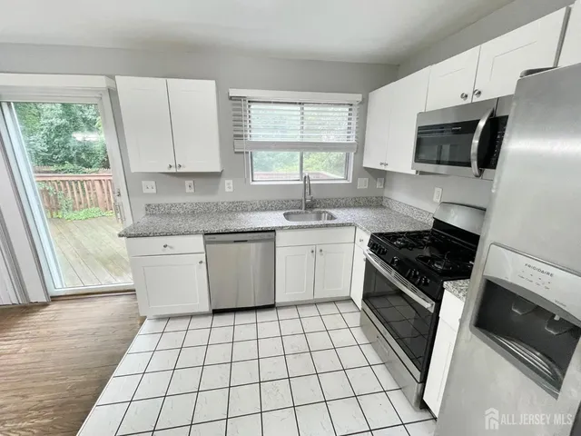 a kitchen with stainless steel appliances a sink a stove a microwave and cabinets