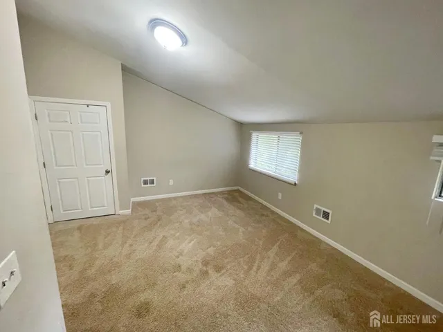 an empty room with a fireplace and windows
