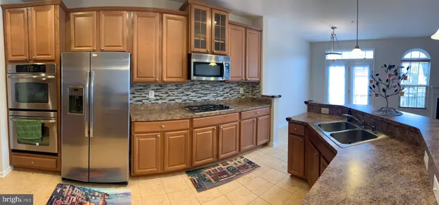 a kitchen with stainless steel appliances granite countertop a refrigerator a sink a stove and island