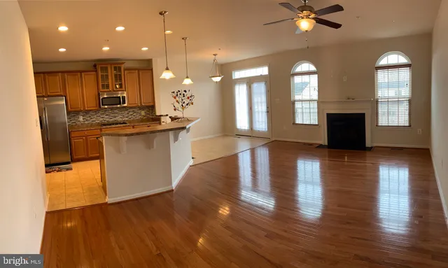 a open kitchen with white cabinets and wooden floor