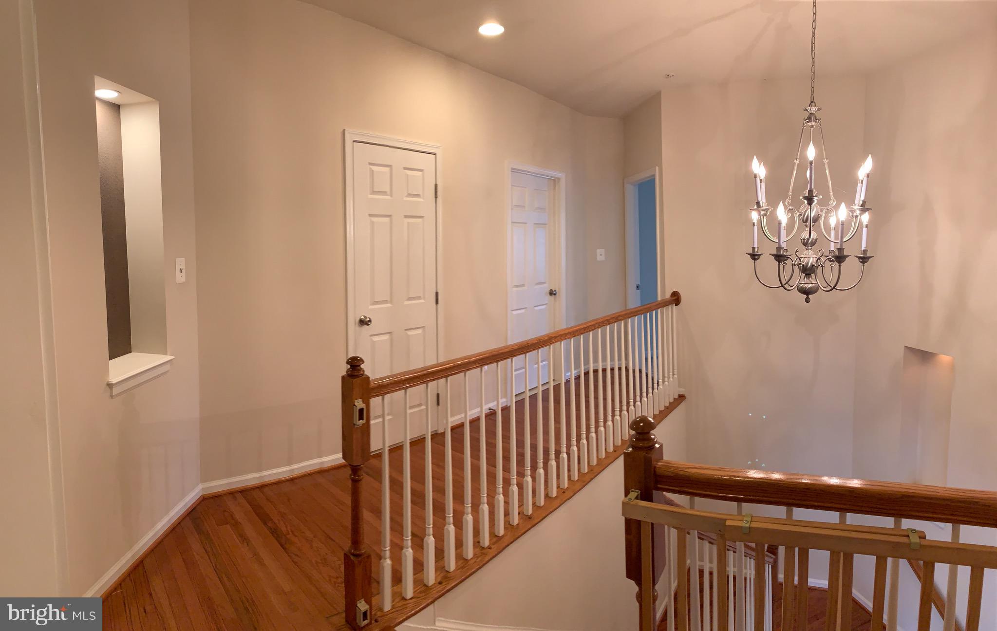 2816 Admiral Ridge Road Accokeek, MD 20607 - Photo 24 of 38 a view of a hallway with wooden floor and chandelier