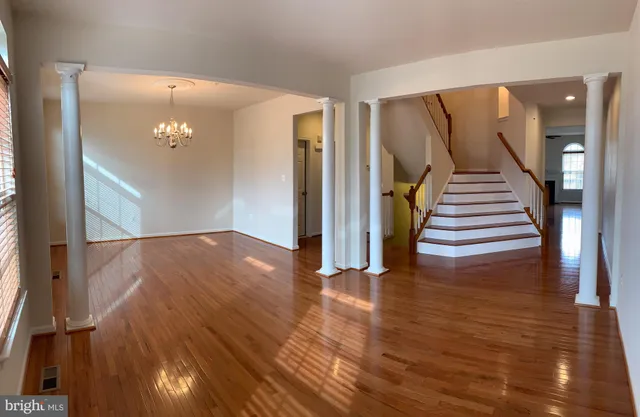 a view of a hallway with wooden floor and stairs