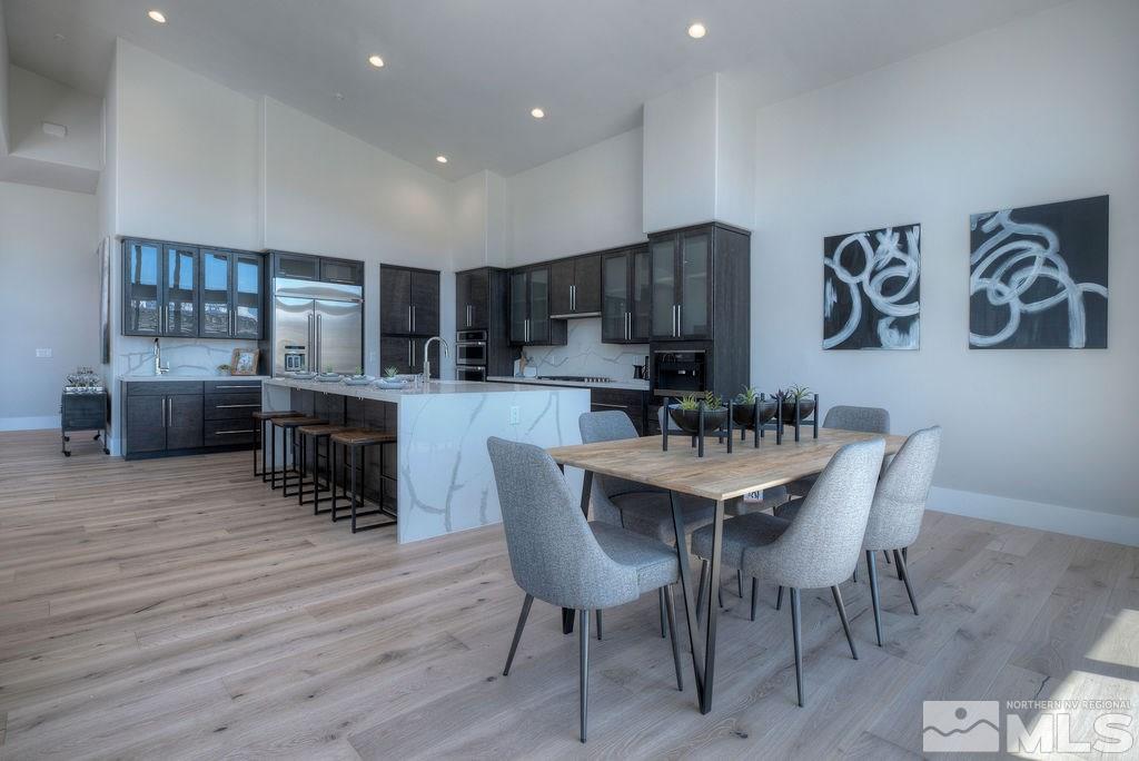 2372 Diamond J Place Reno, NV 89511 - Photo 6 of 25 a kitchen with granite countertop a table chairs stove and a wooden floor
