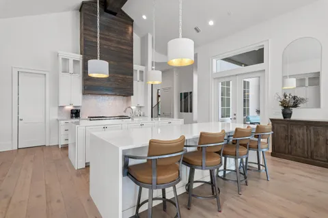 a bathroom with a granite countertop sink two mirror and a bathtub