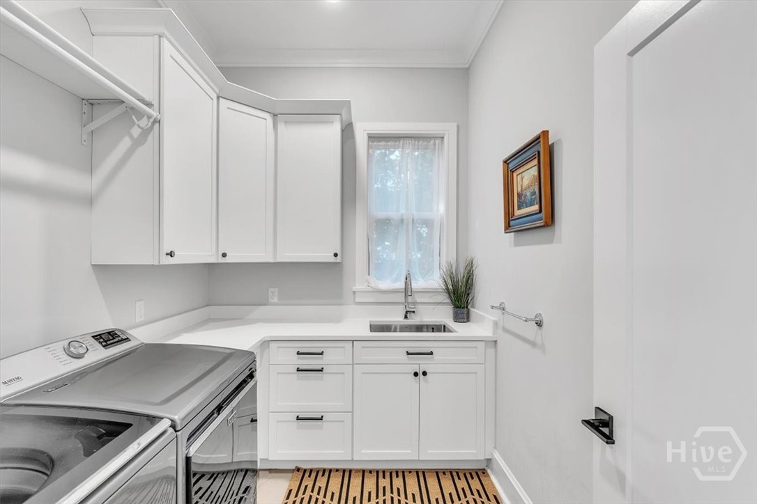 822 Dancy Avenue Savannah, GA 31419 - Photo 33 of 74 Spacious laundry with sink, hanging rod, and storage cabinetry.