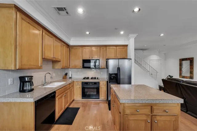 a kitchen with stainless steel appliances granite countertop a sink stove microwave and refrigerator