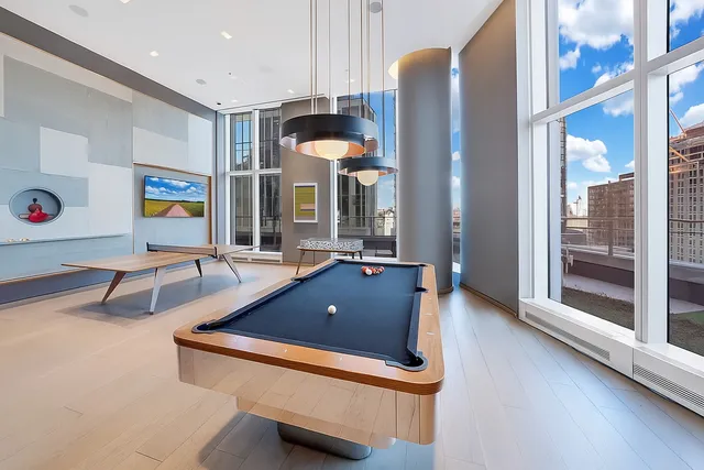 a room with pool table and windows