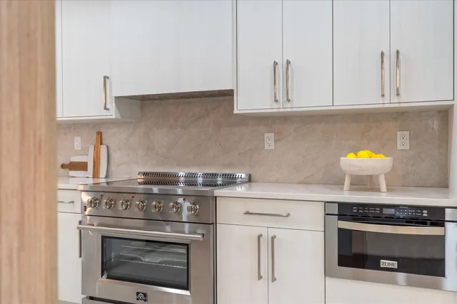 a kitchen with white cabinets and white appliances