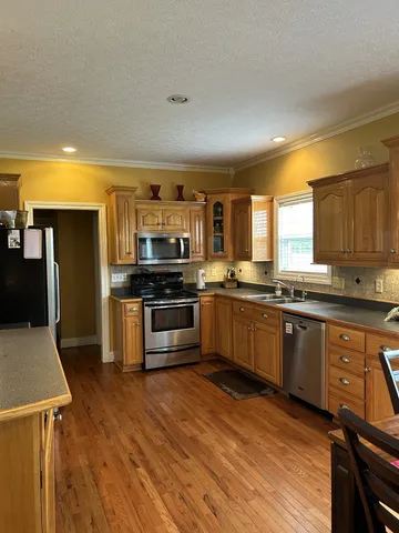 a kitchen with stainless steel appliances kitchen island wooden cabinets and granite counter tops