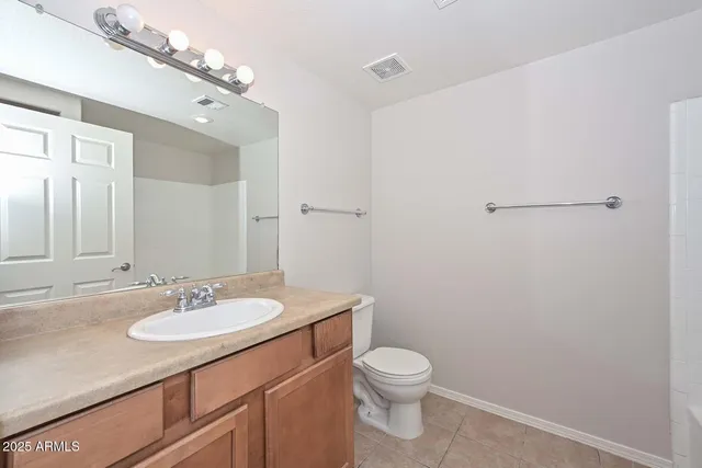 a bathroom with a sink a toilet a mirror and vanity