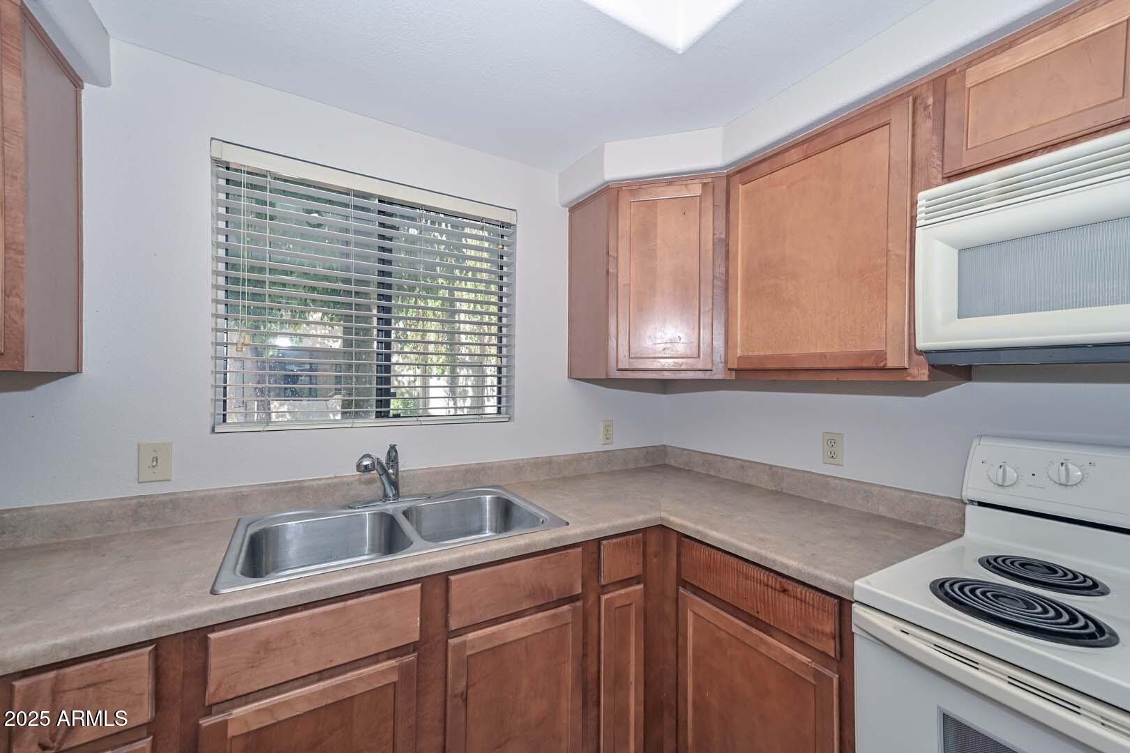 750 East Northern Avenue, Unit 1094 Phoenix, AZ 85020 - Photo 22 of 35 a kitchen with sink cabinets and window