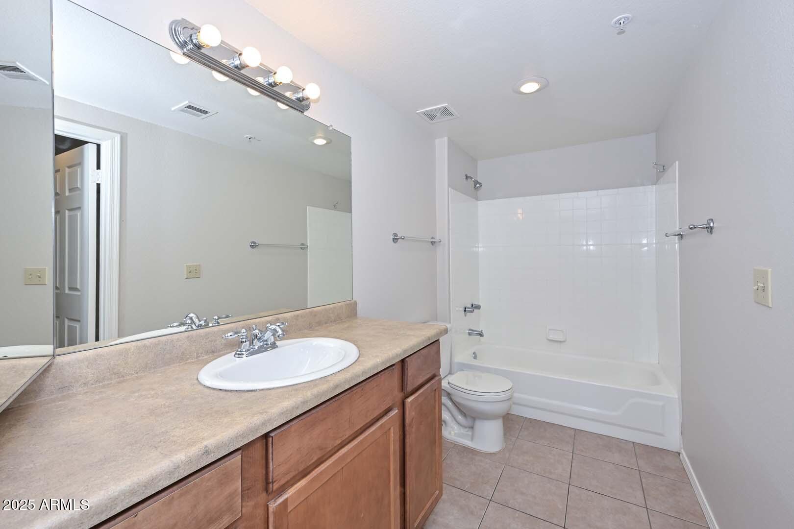 750 East Northern Avenue, Unit 1094 Phoenix, AZ 85020 - Photo 25 of 35 a bathroom with a granite countertop sink a toilet a shower and a mirror