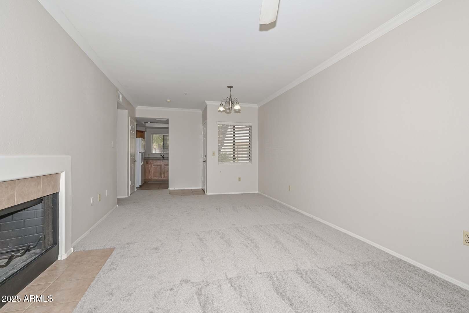 750 East Northern Avenue, Unit 1094 Phoenix, AZ 85020 - Photo 6 of 35 an empty room with chandelier and fireplace