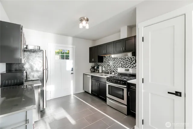 a kitchen with stainless steel appliances granite countertop a refrigerator and a stove