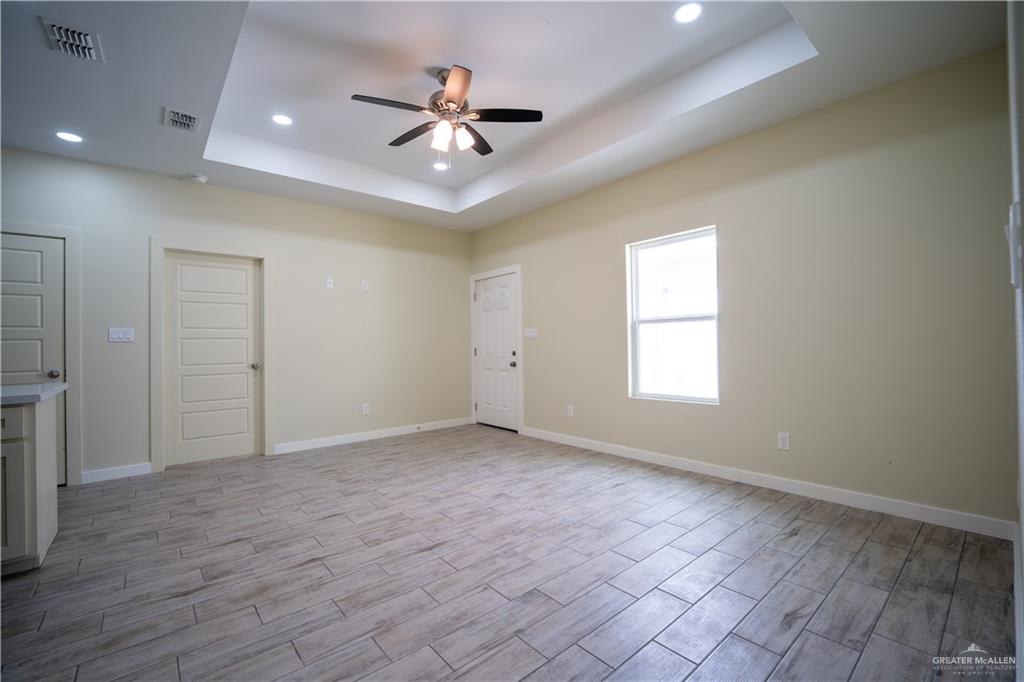 3086 Briggs Road, Unit B Weslaco, TX 78596 - Photo 2 of 15 Spare room with ceiling fan, wood finish floors, recessed lighting, and a raised ceiling