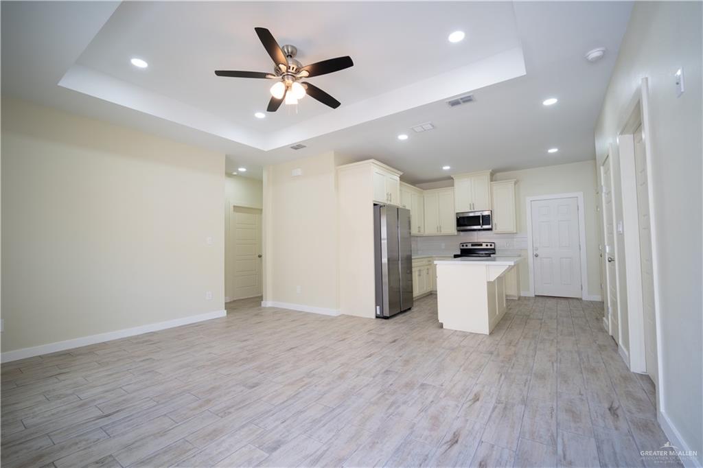 3086 Briggs Road, Unit B Weslaco, TX 78596 - Photo 15 of 15 Kitchen with a kitchen island, open floor plan, stainless steel appliances, a ceiling fan, and light wood-style floors