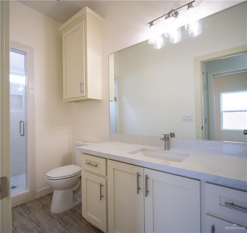 3086 Briggs Road, Unit B Weslaco, TX 78596 - Photo 9 of 15 Bathroom featuring vanity, a shower stall, and wood finish floors