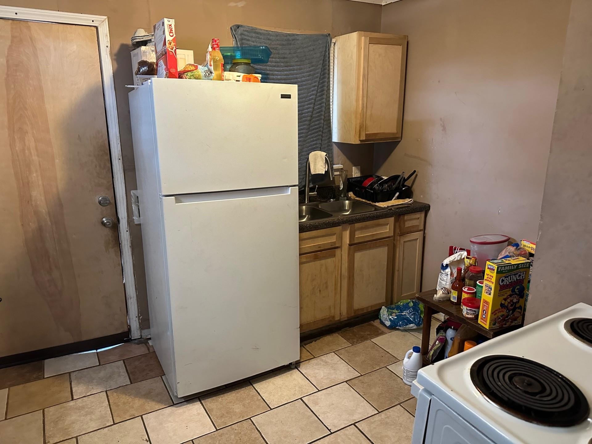 1435 Silver Street Memphis, TN 38106 - Photo 4 of 7 Kitchen featuring white appliances, dark countertops, and light brown cabinets