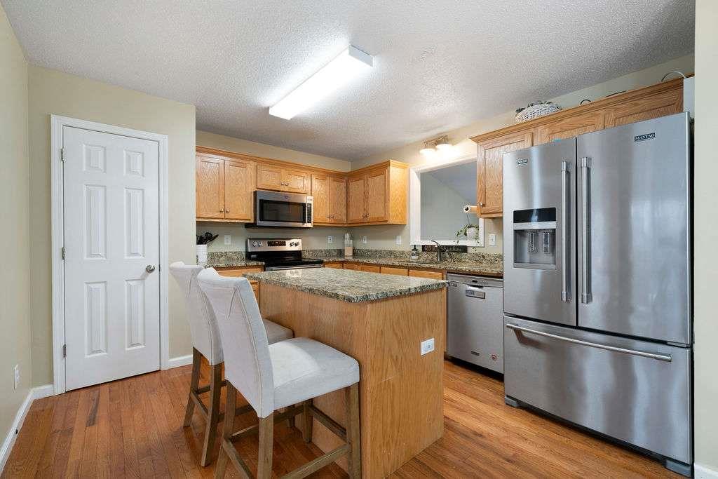 39 Rosemary Path Rockmart, GA 30153 - Photo 10 of 30 a kitchen with stainless steel appliances granite countertop a refrigerator a stove a sink dishwasher a dining table and chairs with wooden floor