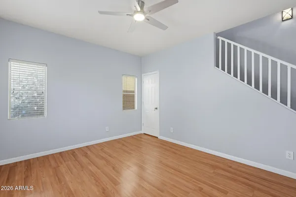 a view of an empty room with wooden floor and a window