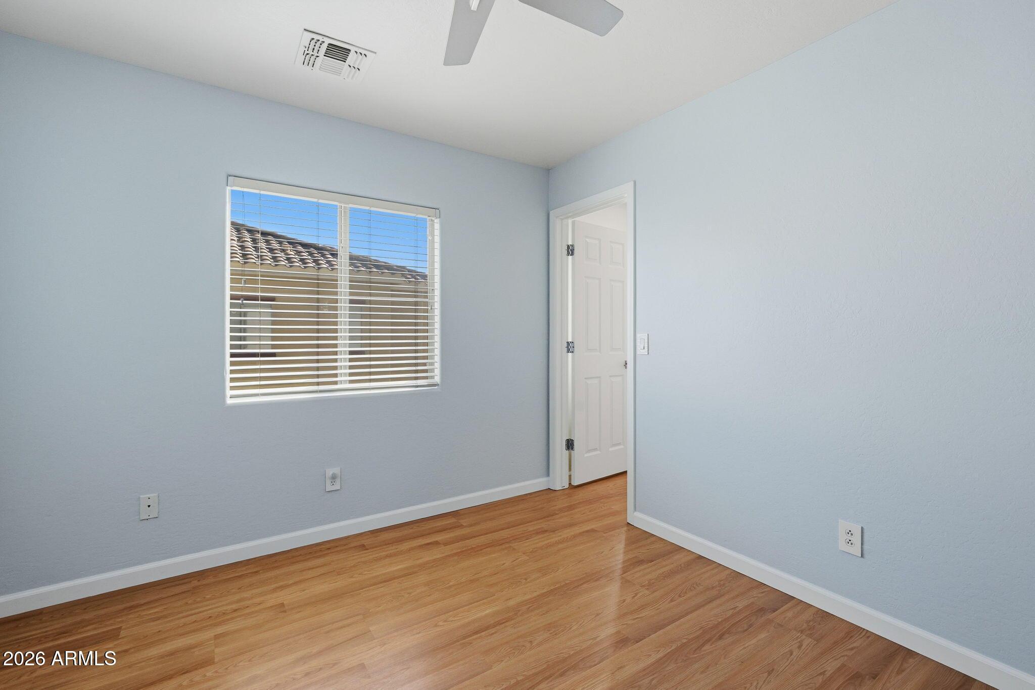 4678 East Redfield Road Gilbert, AZ 85234 - Photo 16 of 31 a view of an empty room with wooden floor and a window