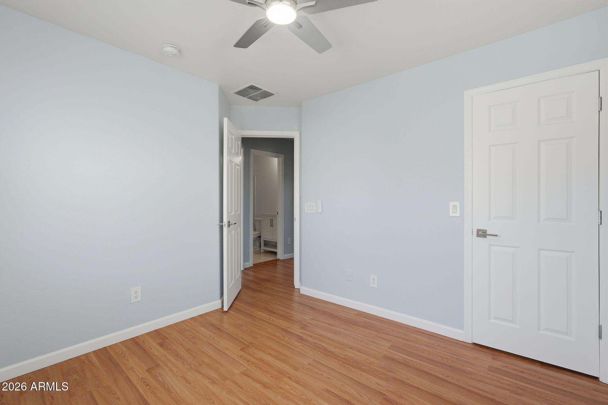 4678 East Redfield Road Gilbert, AZ 85234 - Photo 19 of 31 an empty room with wooden floor fan and windows