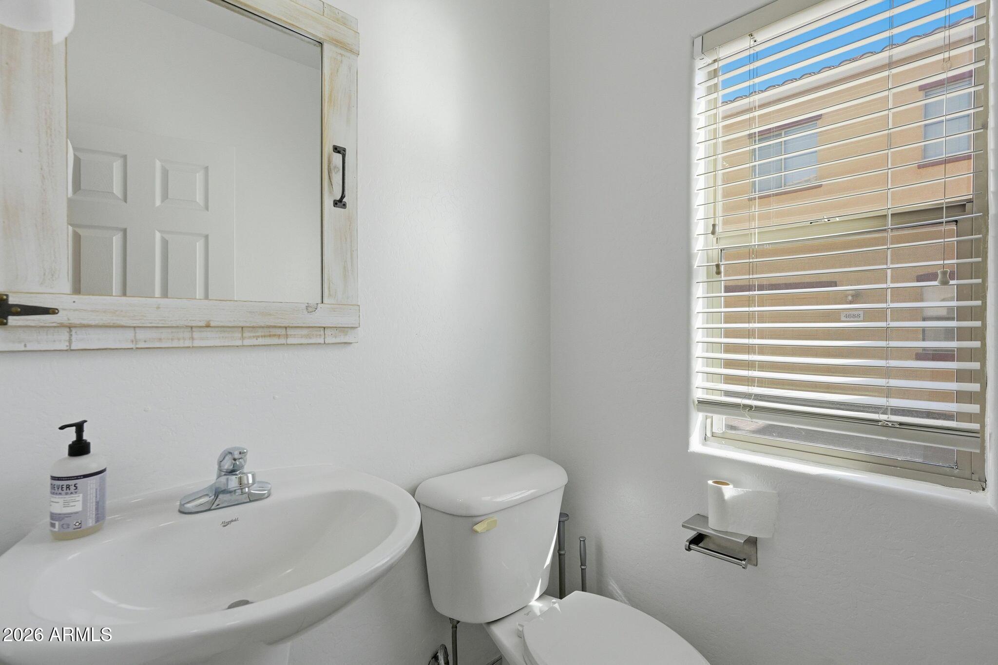 4678 East Redfield Road Gilbert, AZ 85234 - Photo 27 of 31 a bathroom with a sink a toilet and a mirror