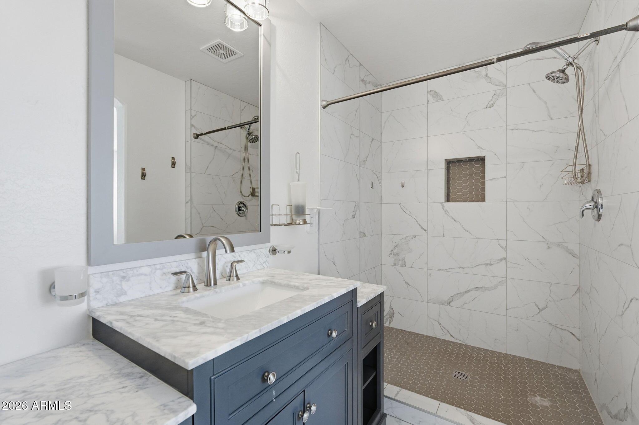 4678 East Redfield Road Gilbert, AZ 85234 - Photo 29 of 31 a bathroom with a sink shower and a mirror