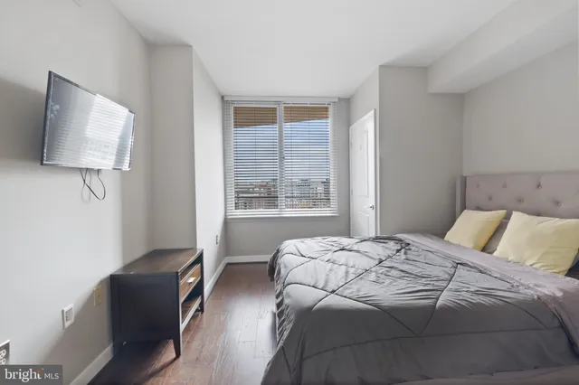 a bedroom with a bed and a flat tv screen in it