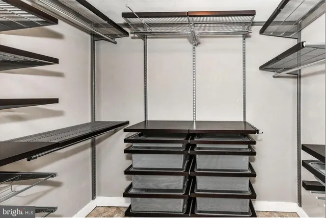 a view of walk in closet with clothes and shoes