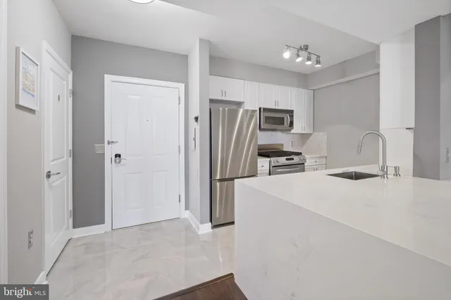 a kitchen with a sink cabinets and wooden floor