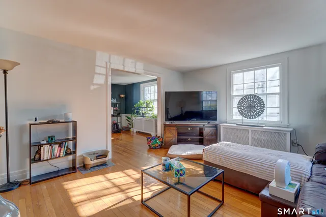 a living room with furniture a flat screen tv and a window