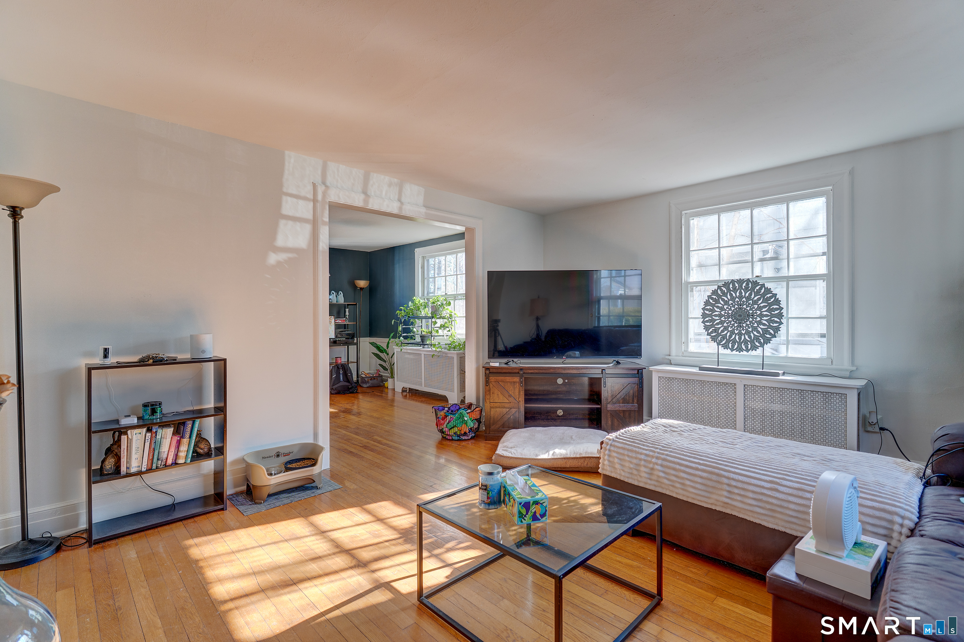 a living room with furniture a flat screen tv and a window