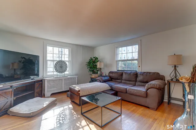 a living room with furniture a flat screen tv and a window