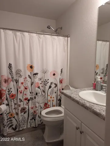 a bathroom with a granite countertop sink a toilet and a mirror