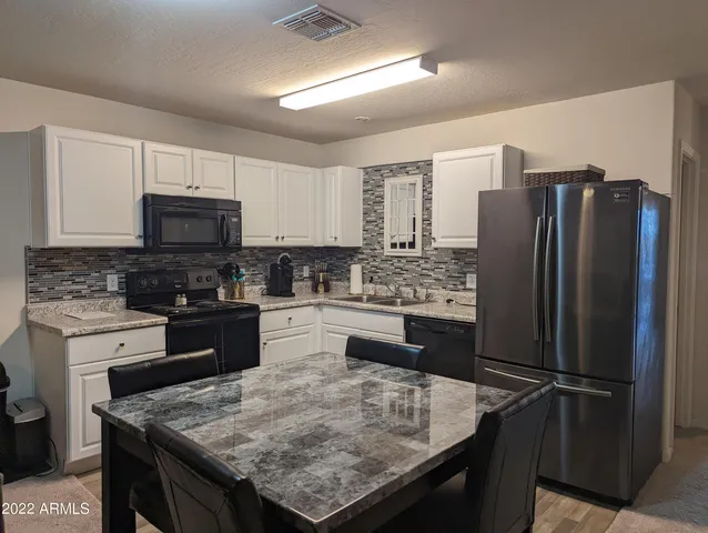 a kitchen with granite countertop stainless steel appliances and wooden cabinets