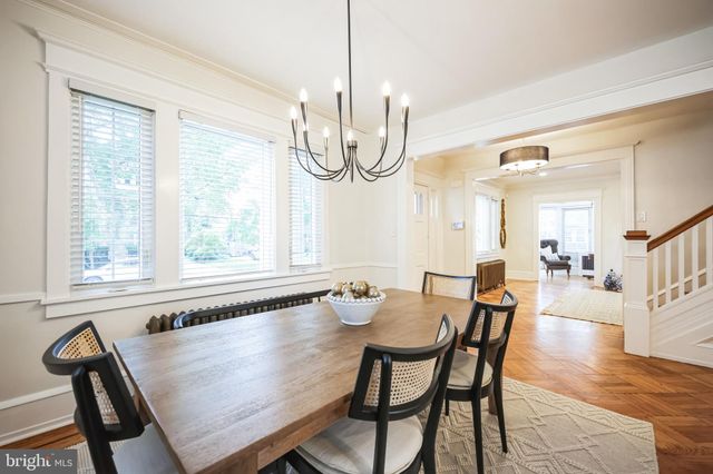 a view of a dining room with furniture a chandelier and wooden floor