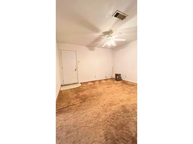 a view of a room with a ceiling fan