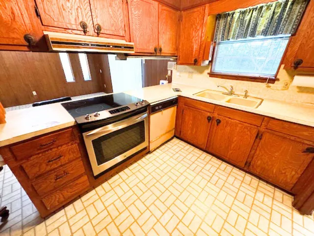 a kitchen with stainless steel appliances granite countertop a stove a sink and a microwave