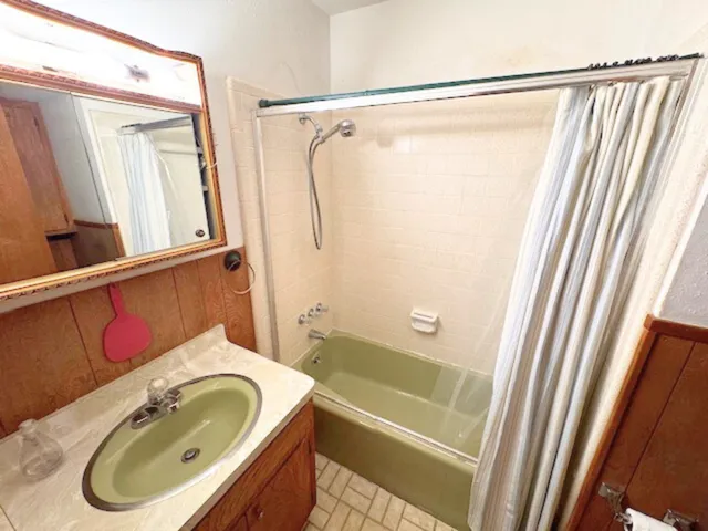 a bathroom with a sink a granite countertop tub and a sink