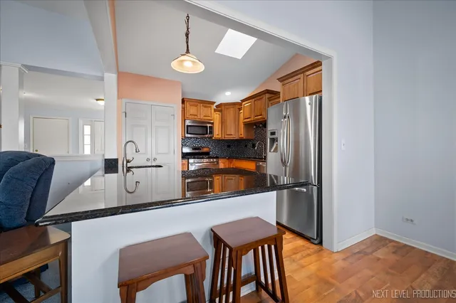 a kitchen with stainless steel appliances granite countertop a refrigerator a sink and a stove